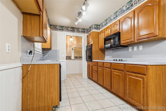8805 E 46th Pl, Tulsa, OK 74145 - kitchen with black appliances, light countertops, a sink, brown cabinetry, and light tile patterned flooring