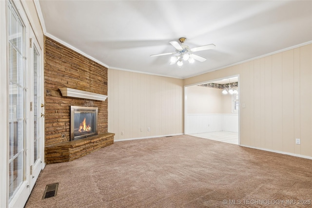 8805 E 46th Pl, Tulsa, OK 74145 - unfurnished living room with crown molding, carpet flooring, a brick fireplace, a ceiling fan, and wooden walls