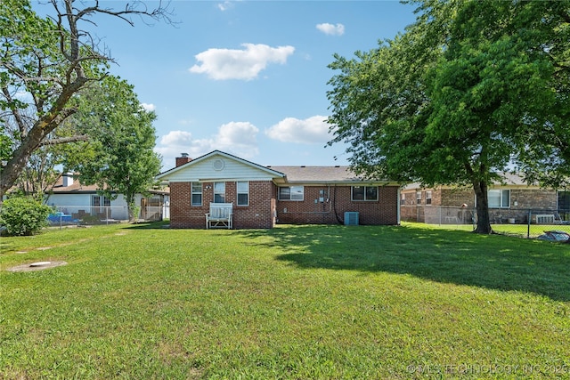 8805 E 46th Pl, Tulsa, OK 74145 - rear view of property featuring brick siding, a chimney, and central AC