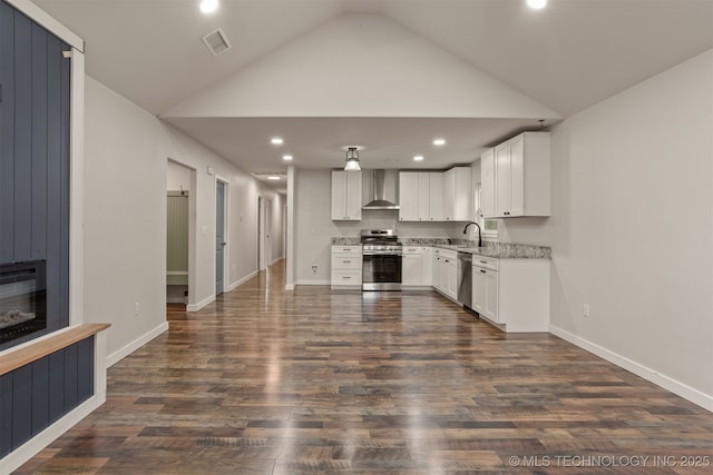 110 S Birch St, Sapulpa, OK 74066 - kitchen with appliances with stainless steel finishes, wall chimney exhaust hood, recessed lighting, white cabinetry, and a fireplace