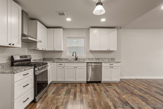 110 S Birch St, Sapulpa, OK 74066 - kitchen featuring appliances with stainless steel finishes, wall chimney exhaust hood, a sink, light stone countertops, and dark wood-style flooring