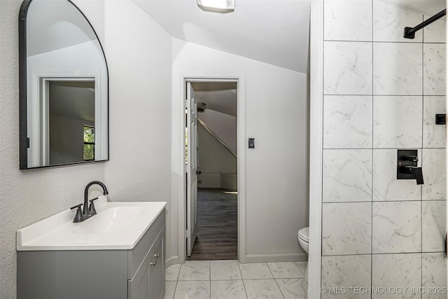 731 8th Ave NW, Ardmore, OK 73401 - bathroom featuring lofted ceiling, vanity, tiled shower, marble finish flooring, and toilet