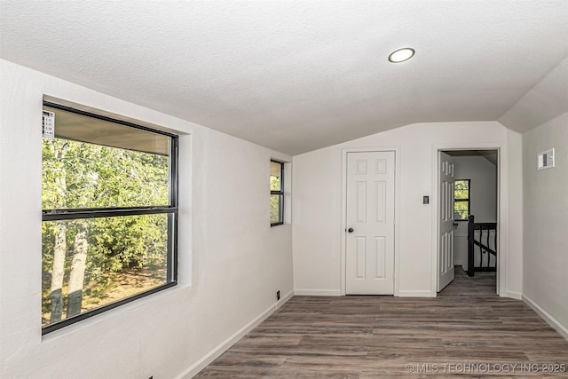 731 8th Ave NW, Ardmore, OK 73401 - empty room with lofted ceiling, dark wood finished floors, a textured ceiling, and baseboards