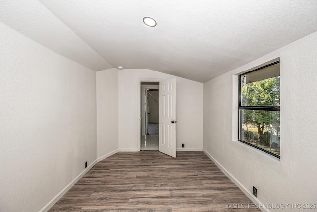 731 8th Ave NW, Ardmore, OK 73401 - empty room with vaulted ceiling, wood finished floors, and baseboards