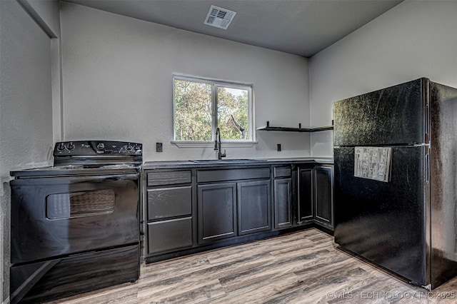 731 8th Ave NW, Ardmore, OK 73401 - kitchen with black appliances, a sink, open shelves, and light wood finished floors