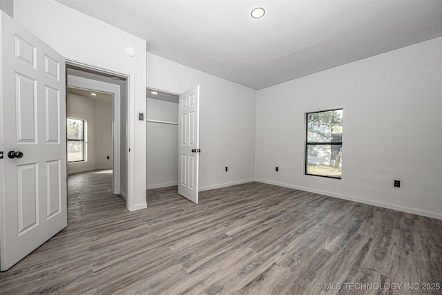 731 8th Ave NW, Ardmore, OK 73401 - unfurnished bedroom featuring multiple windows, wood finished floors, baseboards, a closet, and recessed lighting