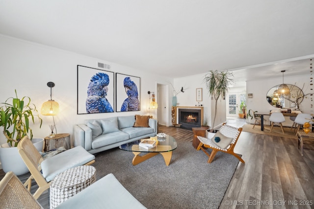 4428 E 68th St Unit 484, Tulsa, OK 74136 - living area featuring wood finished floors, a chandelier, and a warm lit fireplace
