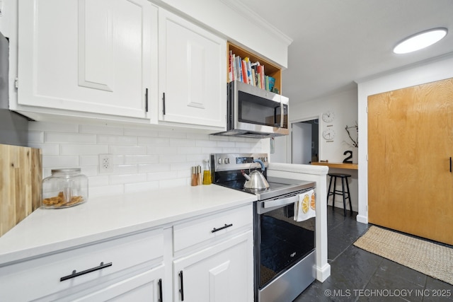 4428 E 68th St Unit 484, Tulsa, OK 74136 - kitchen with stainless steel appliances, white cabinetry, decorative backsplash, and light countertops