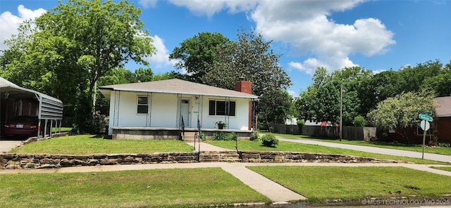 303 W Mckinley Ave, Sapulpa, OK 74066 - bungalow featuring a porch, a chimney, a carport, and concrete driveway