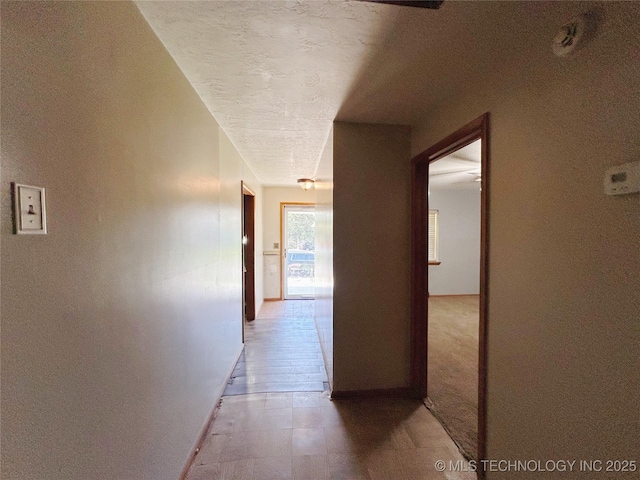 303 W Mckinley Ave, Sapulpa, OK 74066 - corridor featuring baseboards, light flooring, and a textured ceiling