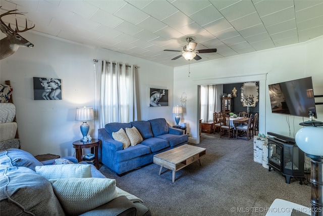 317 E 4th St, Claremore, OK 74017 - living room with healthy amount of natural light, carpet, a wood stove, ceiling fan, and ornamental molding