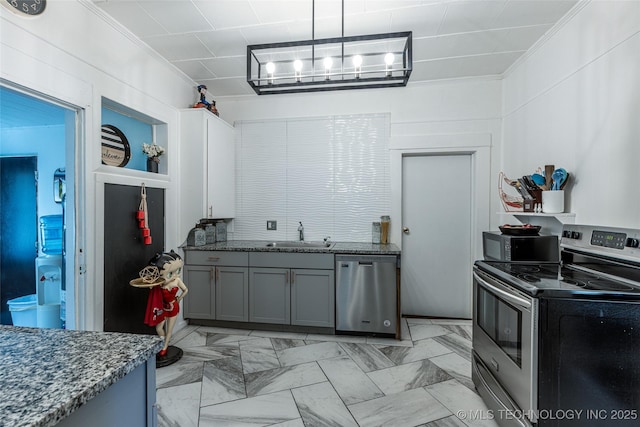 317 E 4th St, Claremore, OK 74017 - kitchen with stainless steel appliances, a sink, crown molding, gray cabinets, and dark stone counters