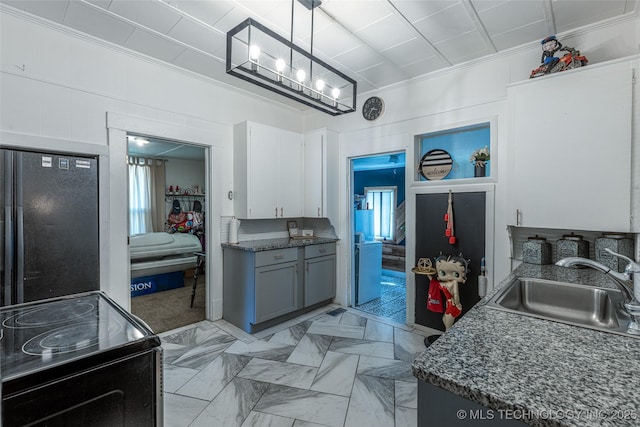 317 E 4th St, Claremore, OK 74017 - kitchen with a sink, black appliances, ornamental molding, hanging light fixtures, and light marble finish floors