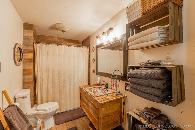 317 E 4th St, Claremore, OK 74017 - bathroom with wood finished floors, a shower with curtain, toilet, and vanity