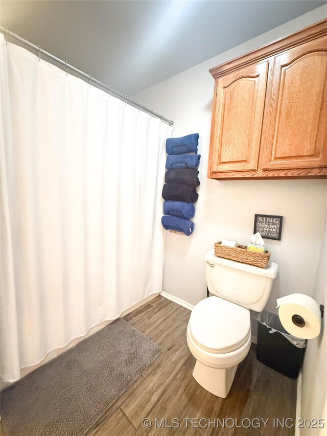 27434 E 113th St, Coweta, OK 74429 - bathroom featuring wood finished floors, baseboards, toilet, and a shower with curtain