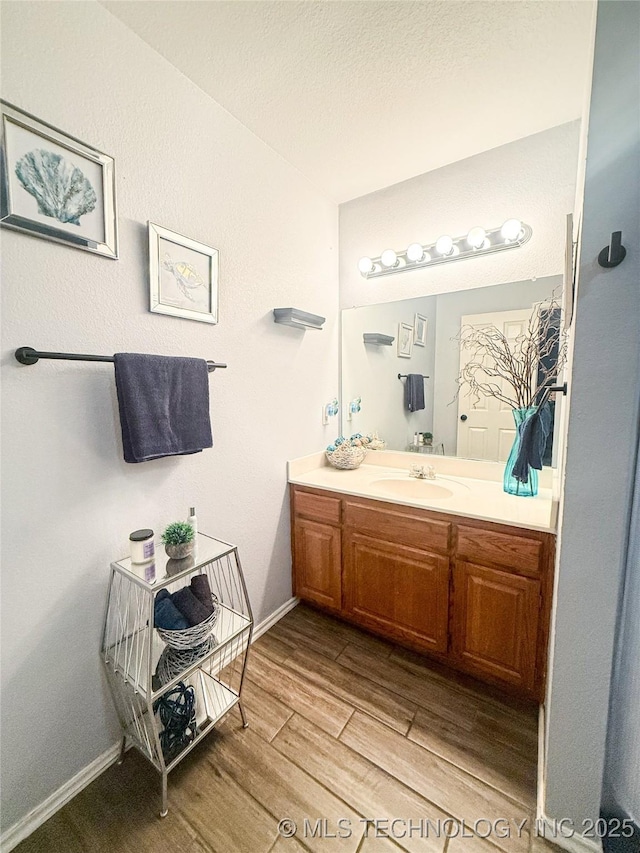 27434 E 113th St, Coweta, OK 74429 - bathroom with wood finished floors, vanity, and baseboards