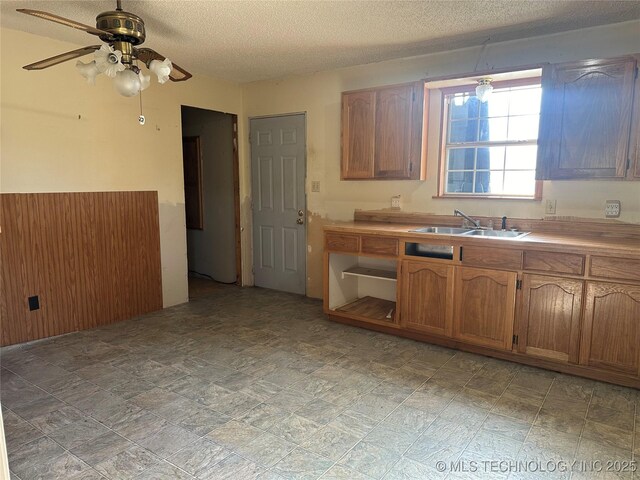 621 S 3rd St, Morris, OK 74445 - kitchen with a sink, a ceiling fan, a textured ceiling, brown cabinetry, and light countertops