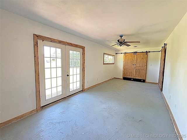 1107 SE 5th St, Wagoner, OK 74467 - unfurnished room featuring french doors, concrete floors, baseboards, and a barn door