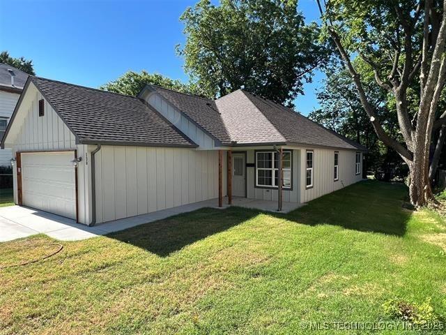 130 W Lincoln Ave, Sapulpa, OK 74066 - view of front facade featuring a front yard, a shingled roof, driveway, and an attached garage