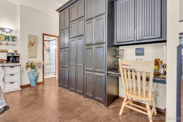 26115 US Highway 70, Bokchito, OK 74726 - kitchen with finished concrete flooring, gray cabinetry, and baseboards