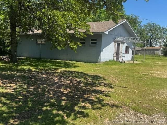 223 W Delaware St, Jay, OK 74346 - view of side of property featuring a lawn and a shingled roof