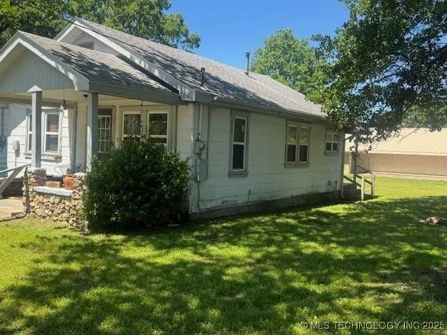 223 W Delaware St, Jay, OK 74346 - view of home's exterior with a lawn and roof with shingles
