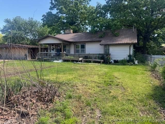 223 W Delaware St, Jay, OK 74346 - rear view of property with a chimney and covered porch