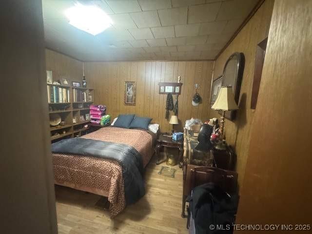 223 W Delaware St, Jay, OK 74346 - bedroom with wood finished floors and wooden walls