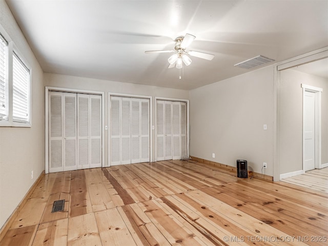 32550 S 250th Rd, Henryetta, OK 74437 - unfurnished bedroom featuring hardwood / wood-style flooring, multiple closets, ceiling fan, and baseboards