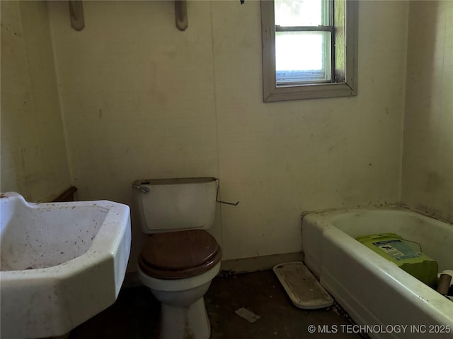 900 S Mabel Ave, Wagoner, OK 74467 - bathroom featuring toilet and a bath