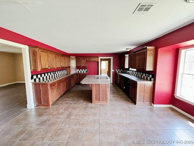21253 S 530th Rd, Tahlequah, OK 74464 - kitchen featuring light tile patterned flooring, a kitchen island with sink, light countertops, and black dishwasher