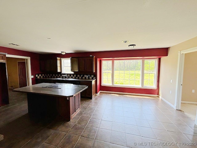 21253 S 530th Rd, Tahlequah, OK 74464 - kitchen featuring a sink, decorative backsplash, tile patterned floors, a kitchen island, and baseboards