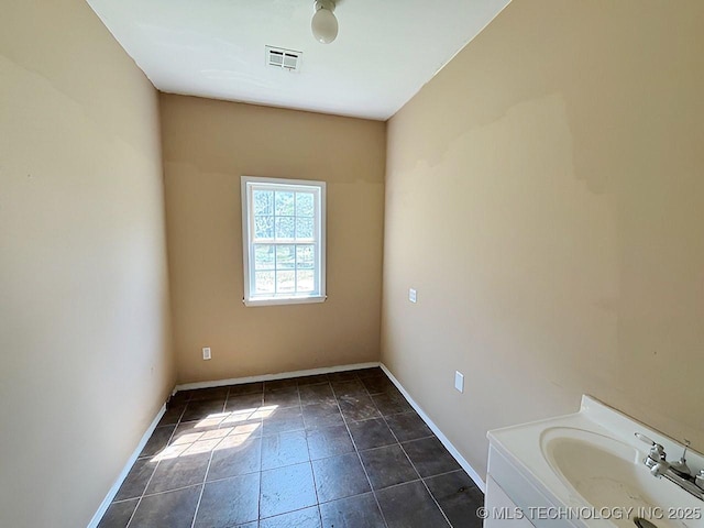 21253 S 530th Rd, Tahlequah, OK 74464 - empty room featuring a sink, baseboards, and dark tile patterned floors