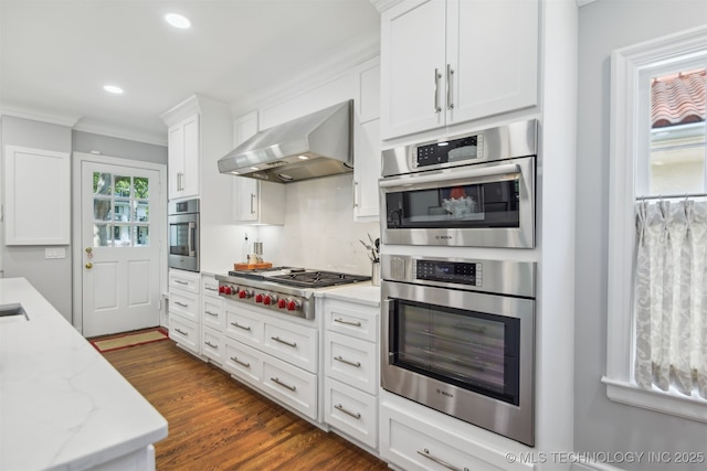 201 E 24th Pl, Tulsa, OK 74114 - kitchen with wall chimney range hood, stainless steel gas stovetop, white cabinets, crown molding, and recessed lighting