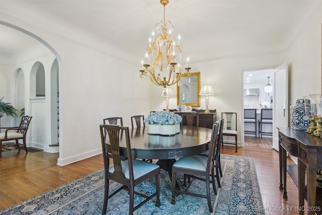 201 E 24th Pl, Tulsa, OK 74114 - dining room with arched walkways, a chandelier, wood finished floors, and baseboards