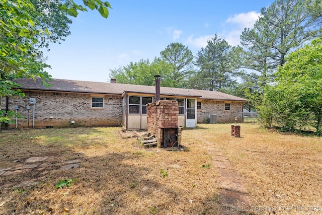 83 Oak St, Durant, OK 74701 - rear view of property featuring brick siding, central air condition unit, and a chimney