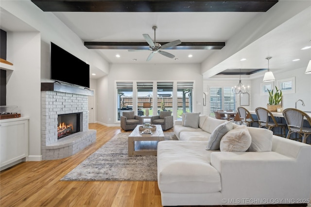 1205 W 88th St S, Tulsa, OK 74132 - living area featuring beamed ceiling, a fireplace, wood finished floors, a ceiling fan, and a chandelier