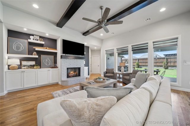 1205 W 88th St S, Tulsa, OK 74132 - living room with beam ceiling, a brick fireplace, a ceiling fan, light wood-style floors, and recessed lighting