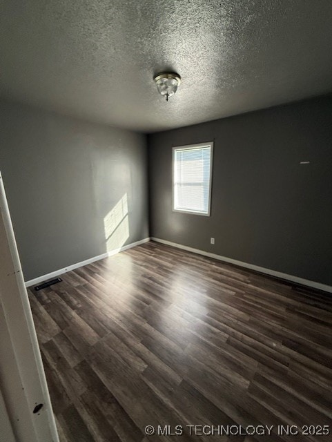 3229 E Cherokee Ave, Sallisaw, OK 74955 - spare room with dark wood-type flooring, baseboards, and a textured ceiling