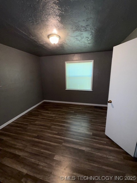 3229 E Cherokee Ave, Sallisaw, OK 74955 - unfurnished room with dark wood-style flooring and baseboards