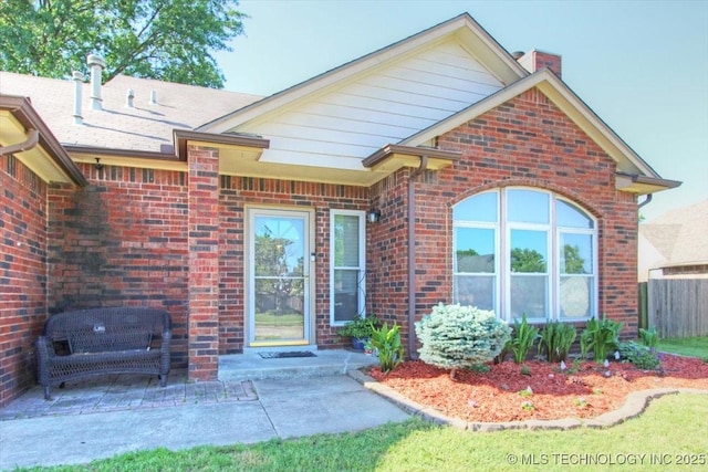 1146 E 137th St, Glenpool, OK 74033 - entrance to property featuring brick siding, a chimney, and a patio