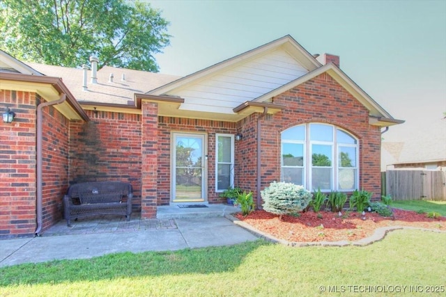 1146 E 137th St, Glenpool, OK 74033 - view of front of house featuring brick siding, a chimney, and a patio