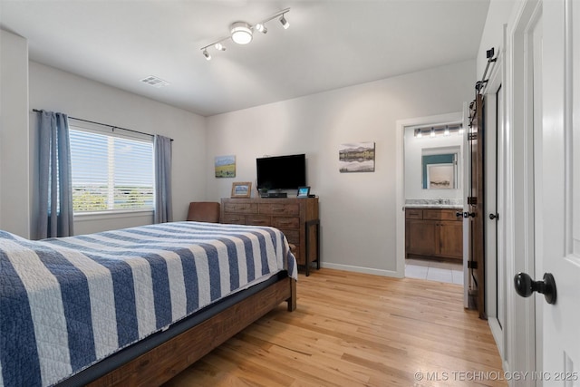 8209 N 150th Ave E, Owasso, OK 74055 - bedroom with light wood-style flooring, baseboards, a sink, and ensuite bath