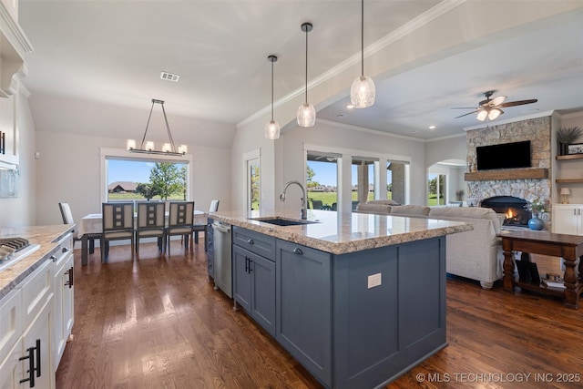 8209 N 150th Ave E, Owasso, OK 74055 - kitchen with a sink, a fireplace, appliances with stainless steel finishes, white cabinets, and dark wood-style flooring