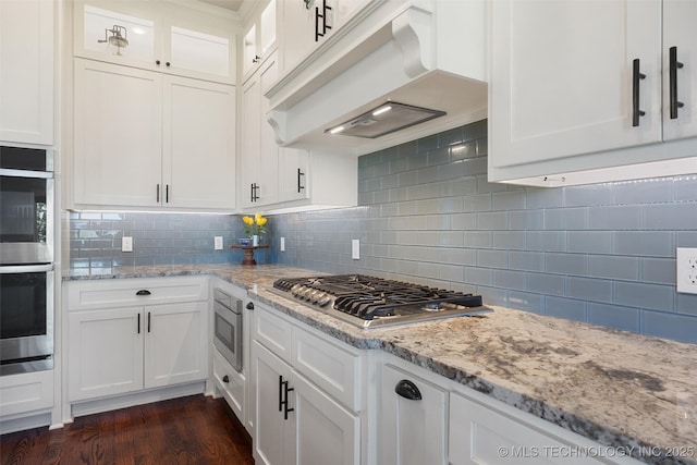 8209 N 150th Ave E, Owasso, OK 74055 - kitchen with premium range hood, appliances with stainless steel finishes, decorative backsplash, and light stone counters