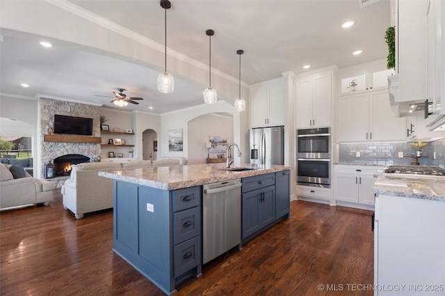 8209 N 150th Ave E, Owasso, OK 74055 - kitchen featuring appliances with stainless steel finishes, crown molding, arched walkways, a sink, and white cabinets