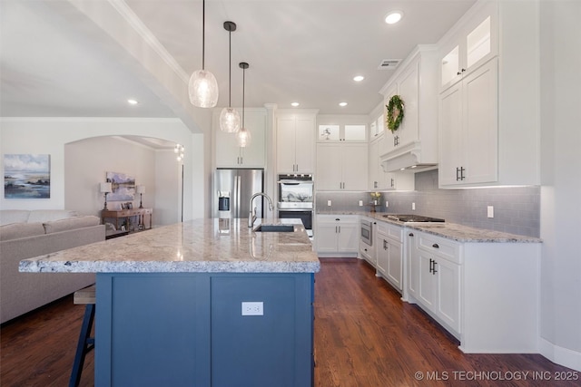 8209 N 150th Ave E, Owasso, OK 74055 - kitchen featuring appliances with stainless steel finishes, a sink, arched walkways, glass insert cabinets, and tasteful backsplash