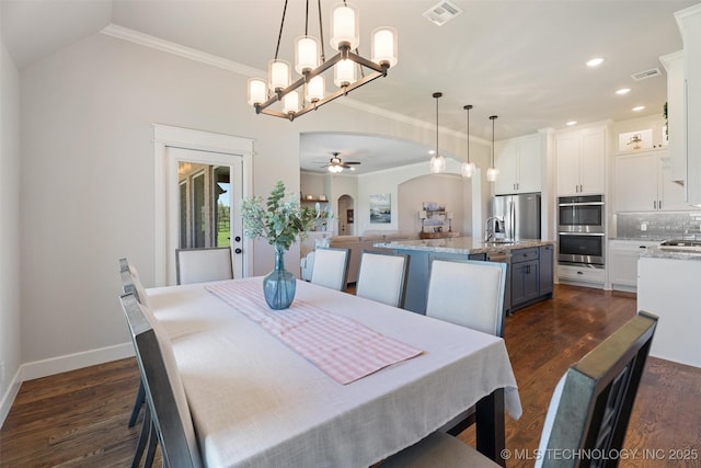 8209 N 150th Ave E, Owasso, OK 74055 - dining space featuring arched walkways, dark wood-type flooring, baseboards, ornamental molding, and ceiling fan