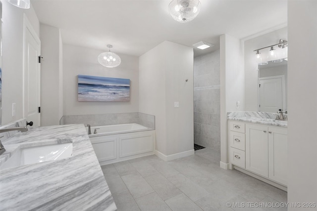 8209 N 150th Ave E, Owasso, OK 74055 - bathroom with two vanities, a bath, walk in shower, and a chandelier