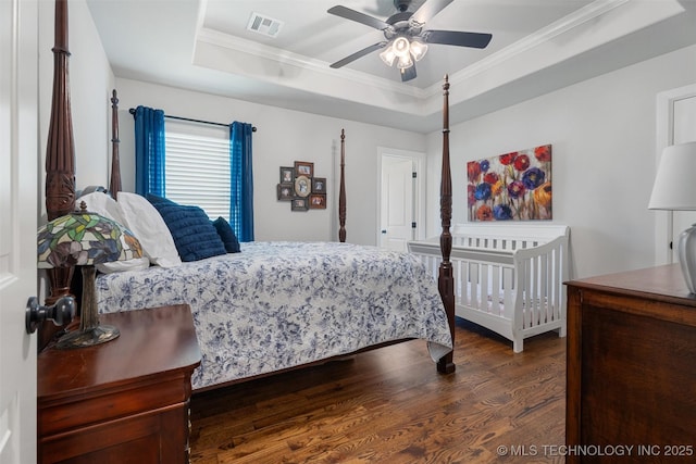 8209 N 150th Ave E, Owasso, OK 74055 - bedroom featuring a tray ceiling, ornamental molding, dark wood-style flooring, and a ceiling fan